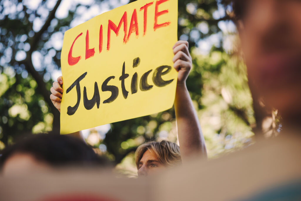 Person holding "Climate Justice" sign.